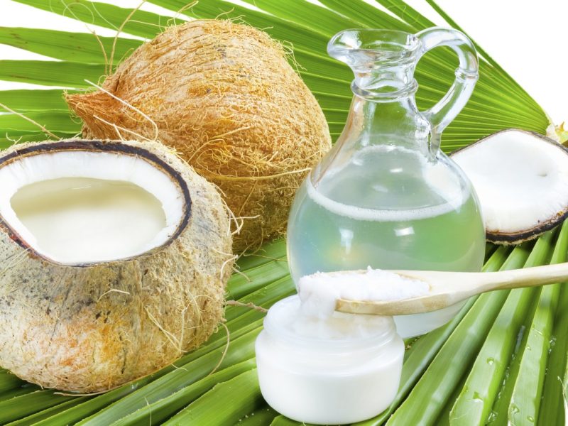 Liquid and solid coconut oil on palm leaf .